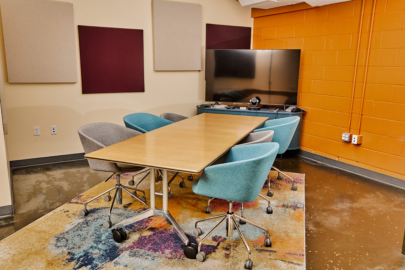 Conference room with large TV screen/monitor and table with six chairs